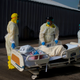 Healthcare workers push a patient into a less intensive unit from the Covid-19 Unit at United Memorial Medical Center in Houston, Texas.